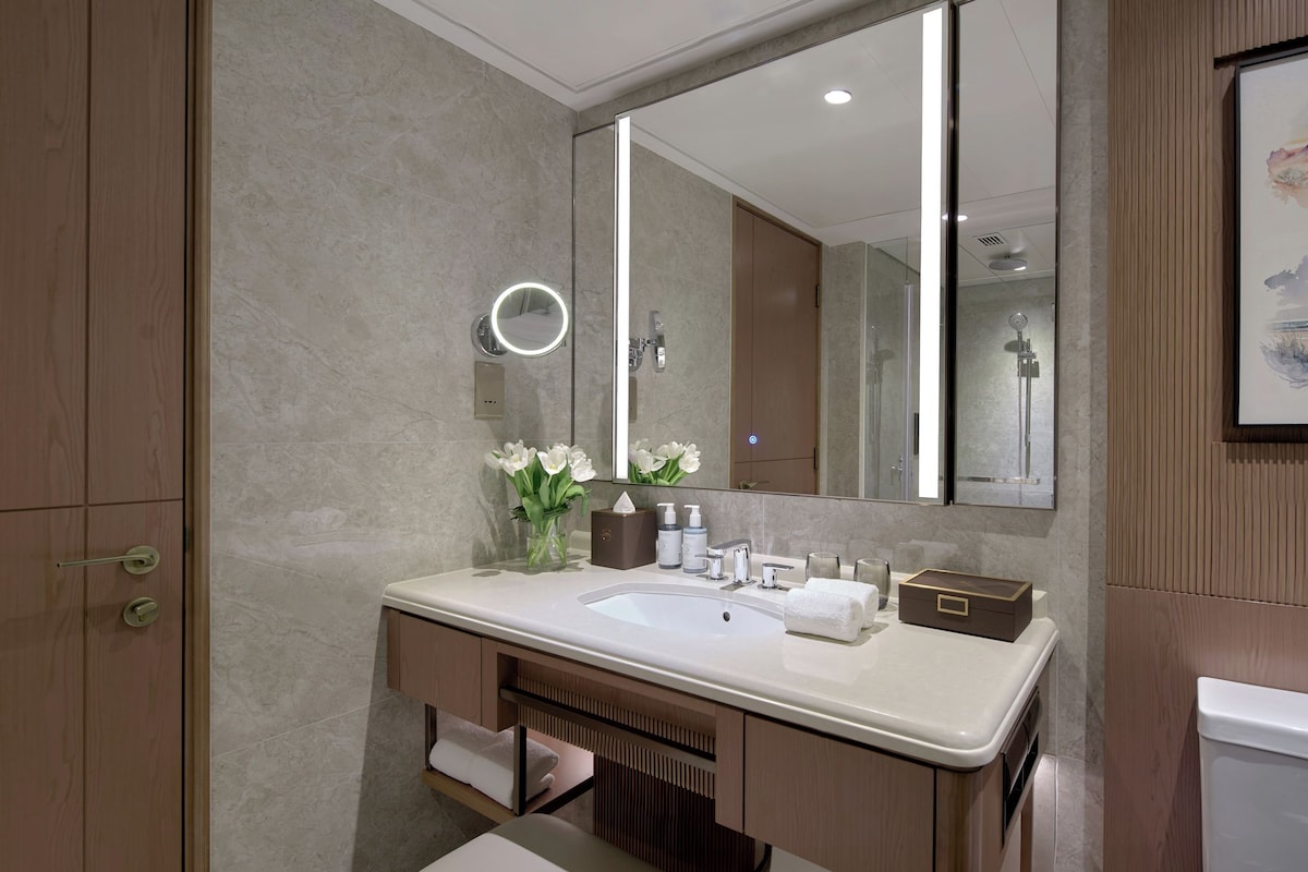 A modern bathroom with a large mirror, a sink, and a vanity.