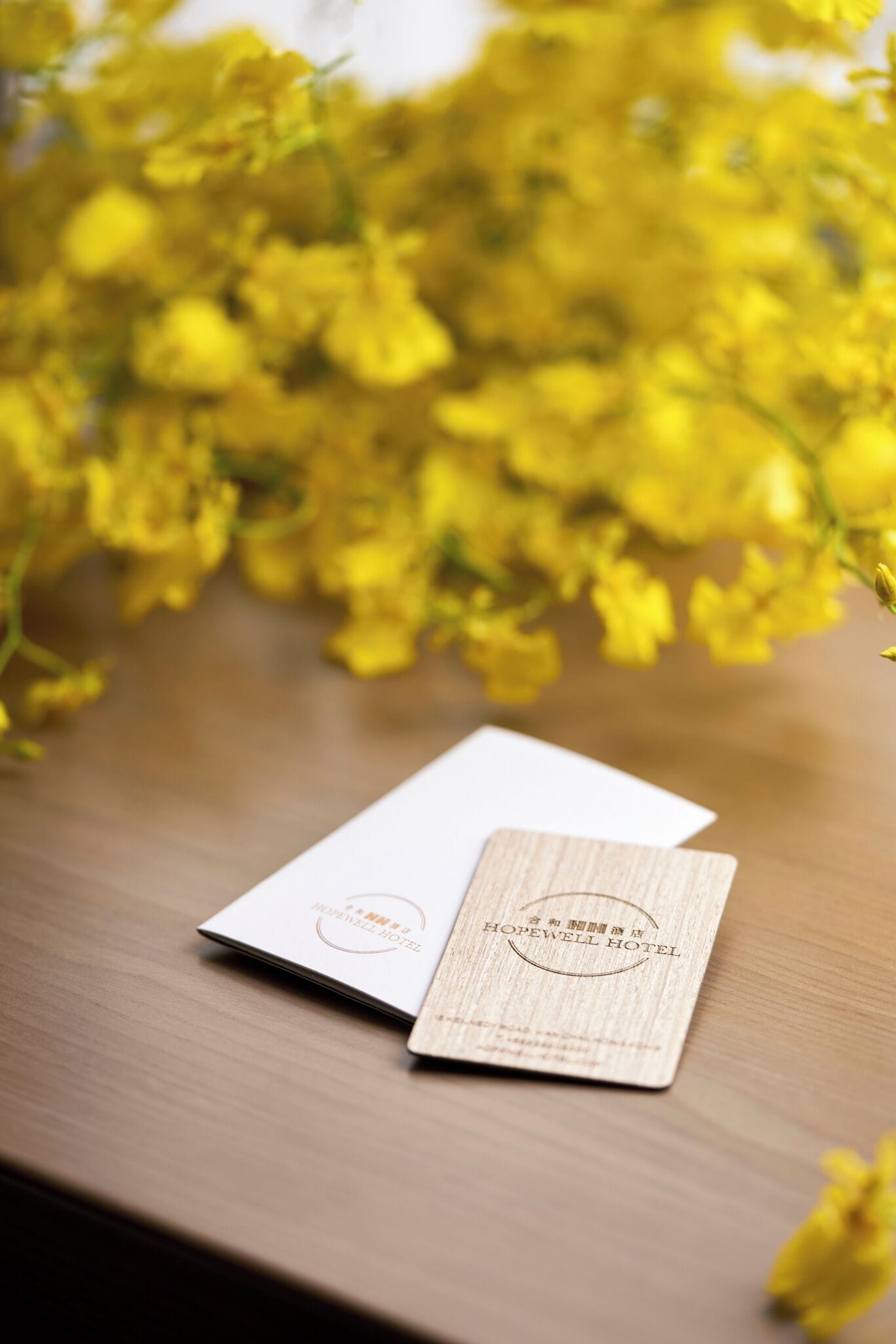 A wooden table with a white card and a wooden plaque with hotel branding.