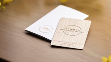 A wooden table with a white card and a wooden plaque with hotel branding.