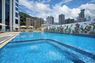 Una piscina al aire libre de temporada, sombrillas