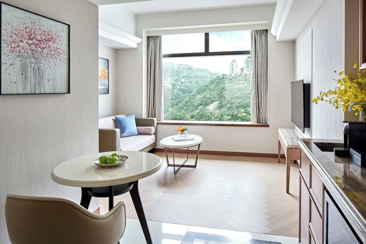 A modern living room with a sofa, a round dining table, and a TV.