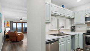 A modern kitchen with light blue cabinets, stainless steel appliances, and a dishwasher. - La Mirage Condo 311 Beachfront Resort Condominiums with Private Boardwalk (Port Aransas)