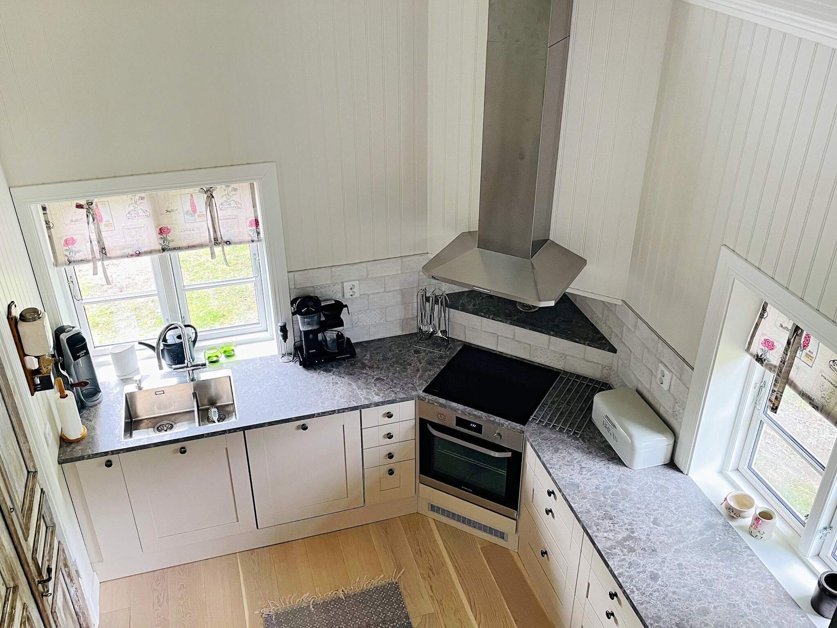 A kitchen with a window, a coffee maker, and a stove.