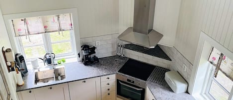 A kitchen with a window, a coffee maker, and a stove.