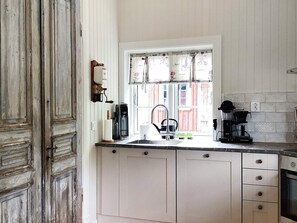 A kitchen with a window, a coffee maker, and a sink. - 4 Person Holiday Home in Allingsas, Sverige (Alingsas)