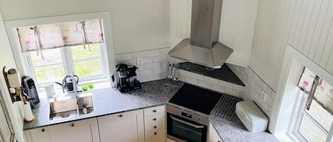 A kitchen with a window, a coffee maker, and a stove.