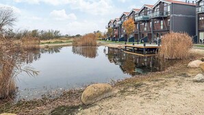 A modern apartment building with a reflective water body in front. - 4 Star Holiday Home in Bogense (Bogense)