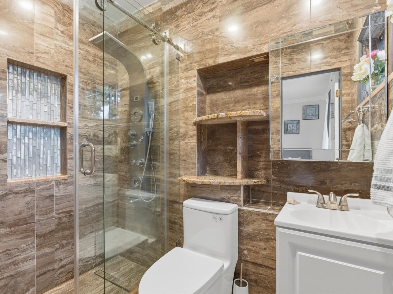 Indulge in the glamorous, large master suite featuring a large walk-in closet, a vanity area, and a beautiful en suite bathroom with marble floors and granite finishes. With its luxury amenities and large windows, this private retreat is your perfect