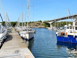 A marina with boats docked along a wooden pier, a bridge in the background, and calm water. - 6 Person Holiday Home in Uddevalla (Uddevalla)