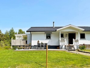 A single-story white house with a dark roof, a front porch, and a fenced backyard. - 6 Person Holiday Home in Uddevalla (Uddevalla)