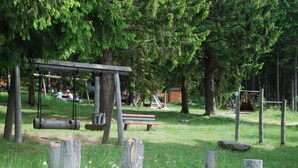A park with a swing set, a picnic table, and a playground.