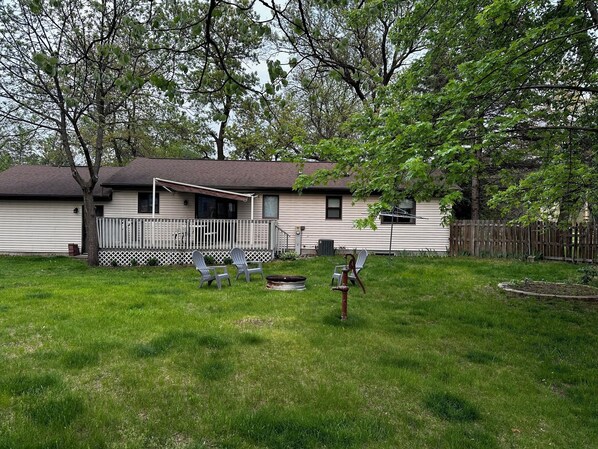 A single-story house with a fenced backyard, a covered patio, and a small garden area.