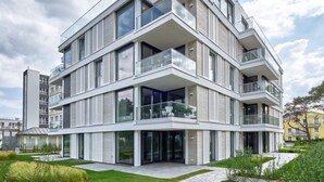 A modern multi-story residential building with balconies, large windows, and a well-maintained garden. - Villa Vogue, Austernfischer (Binz)