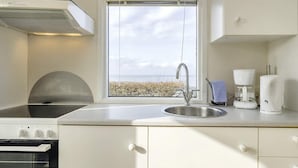A modern kitchen with a stainless steel sink, a built-in oven, and a coffee maker.