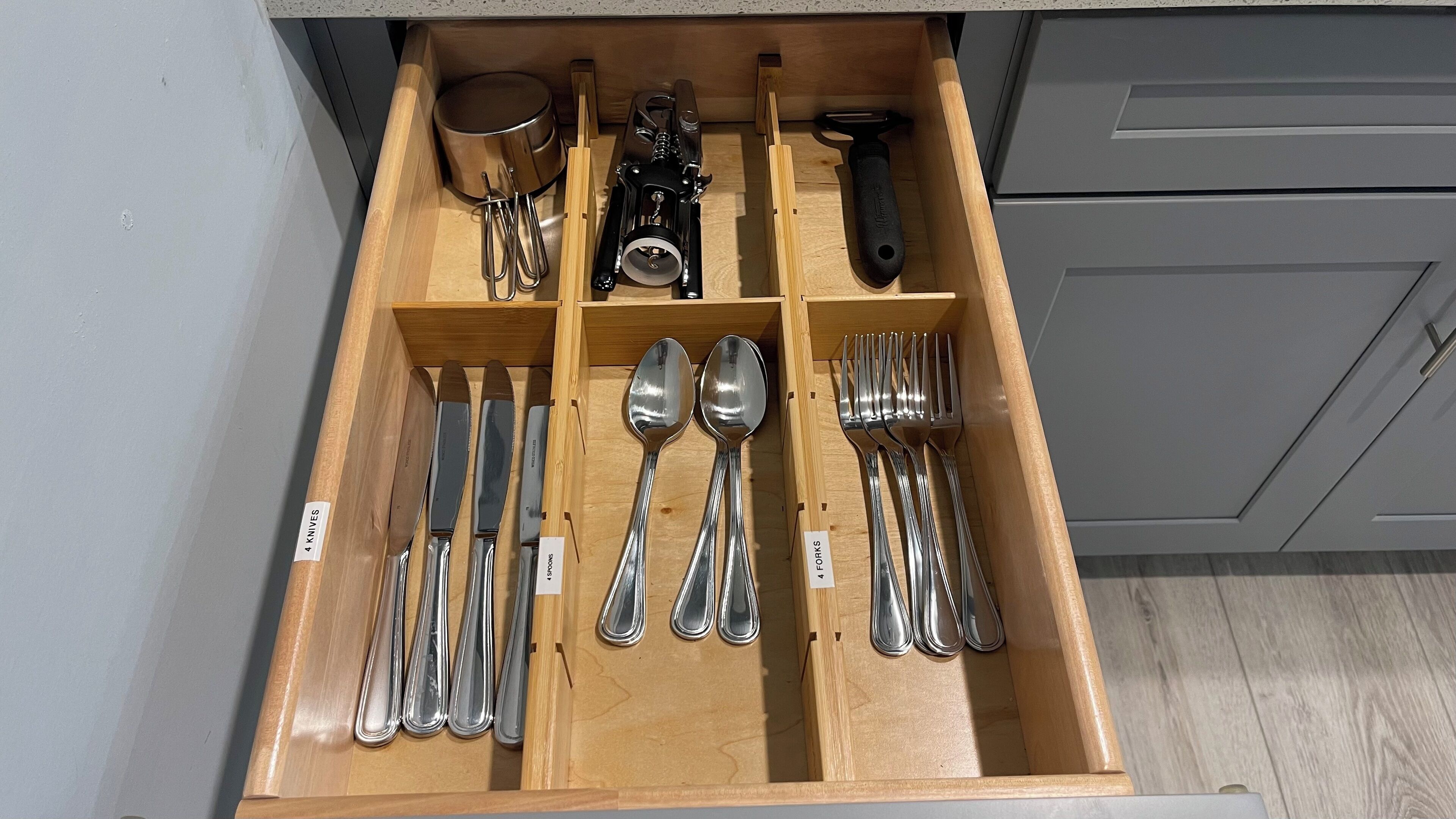 A kitchen drawer with utensils and cookware.