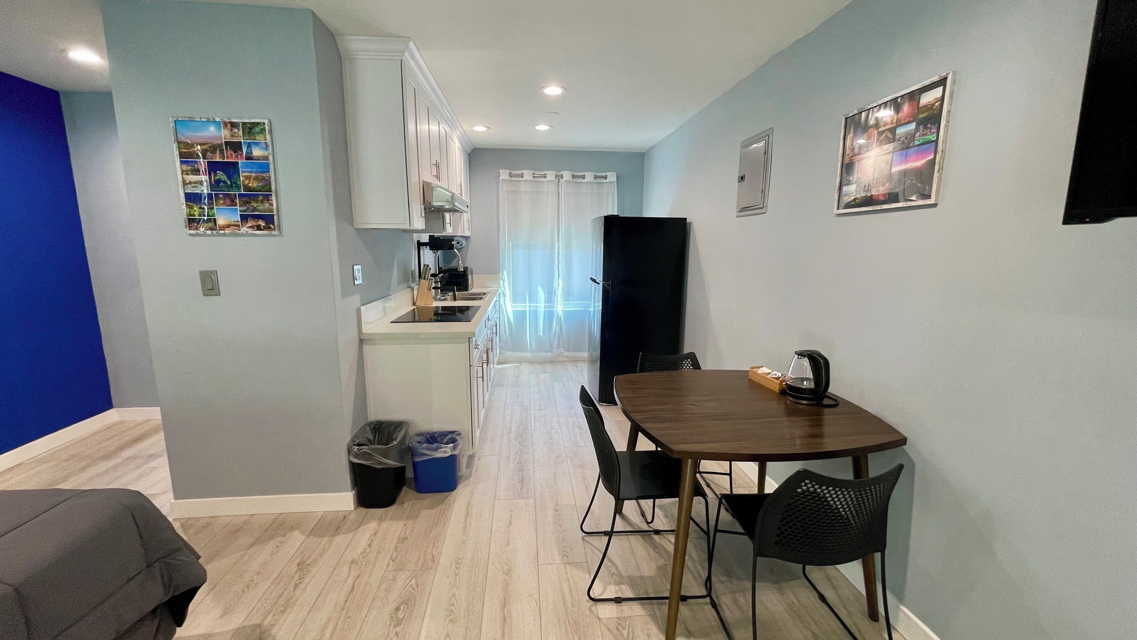 A compact living space with a kitchenette, a dining area with a table and chairs, and a small seating area with a couch.