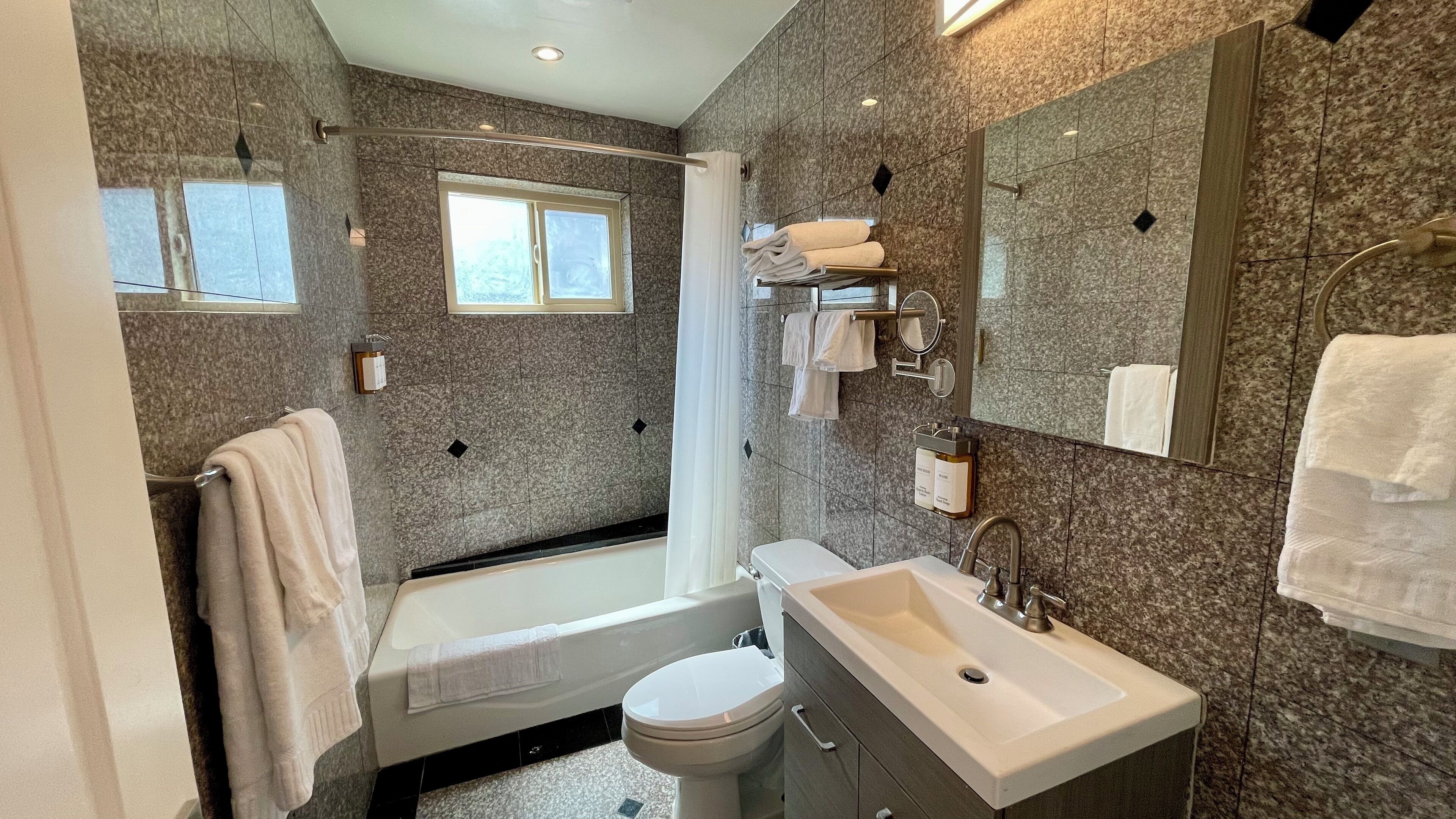A modern bathroom with a bathtub, toilet, and sink.