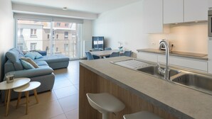 A modern apartment with a kitchen, dining area, and living room.