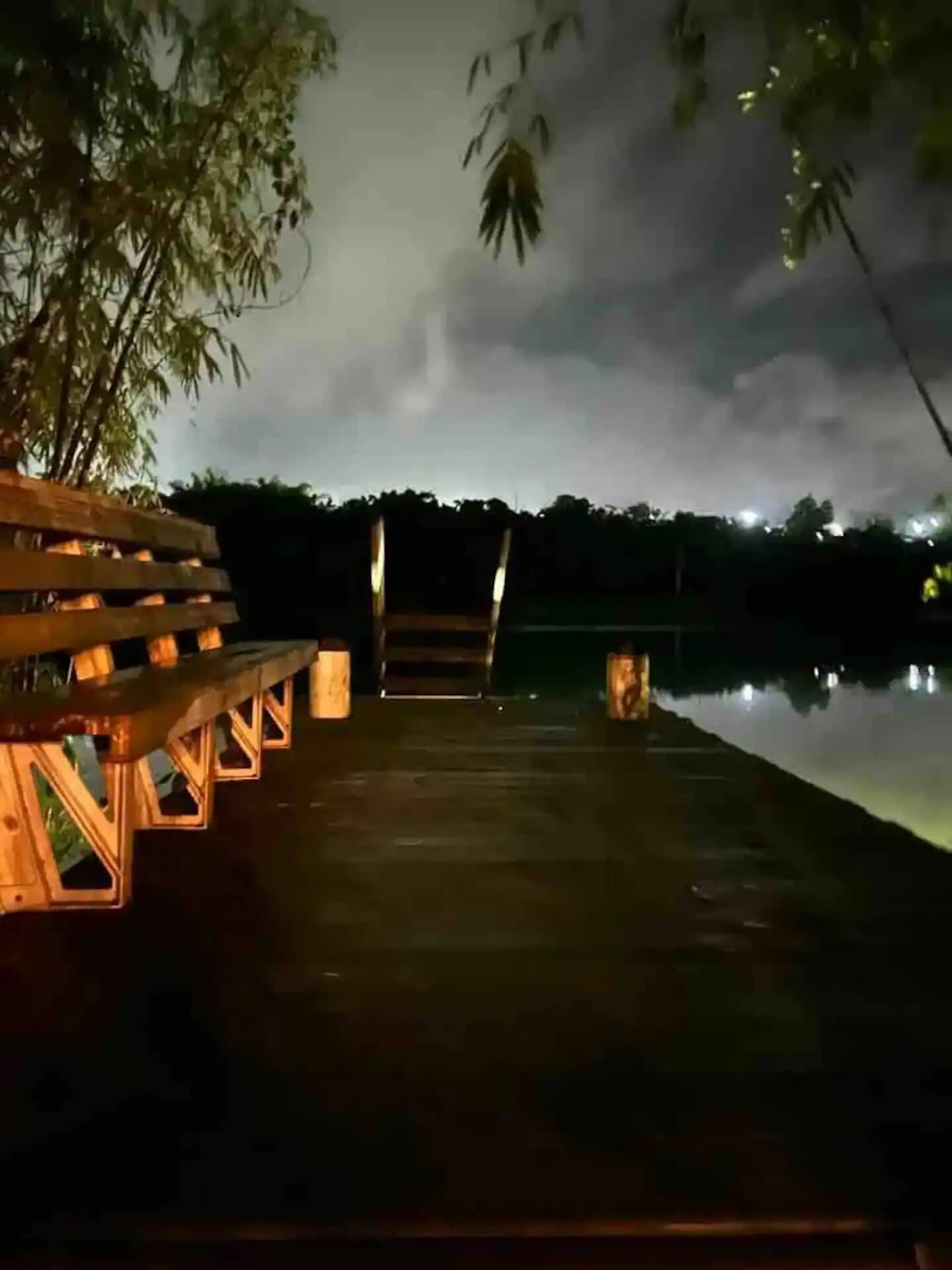 Une jetée en bois s’étendant dans une étendue d’eau, avec un banc situé sur le côté gauche.
