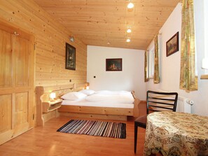 Una habitación de cabaña de madera con una cama, una mesa y una silla.