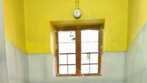 Une petite salle de bain avec des toilettes, une fenêtre et des carreaux décorés.