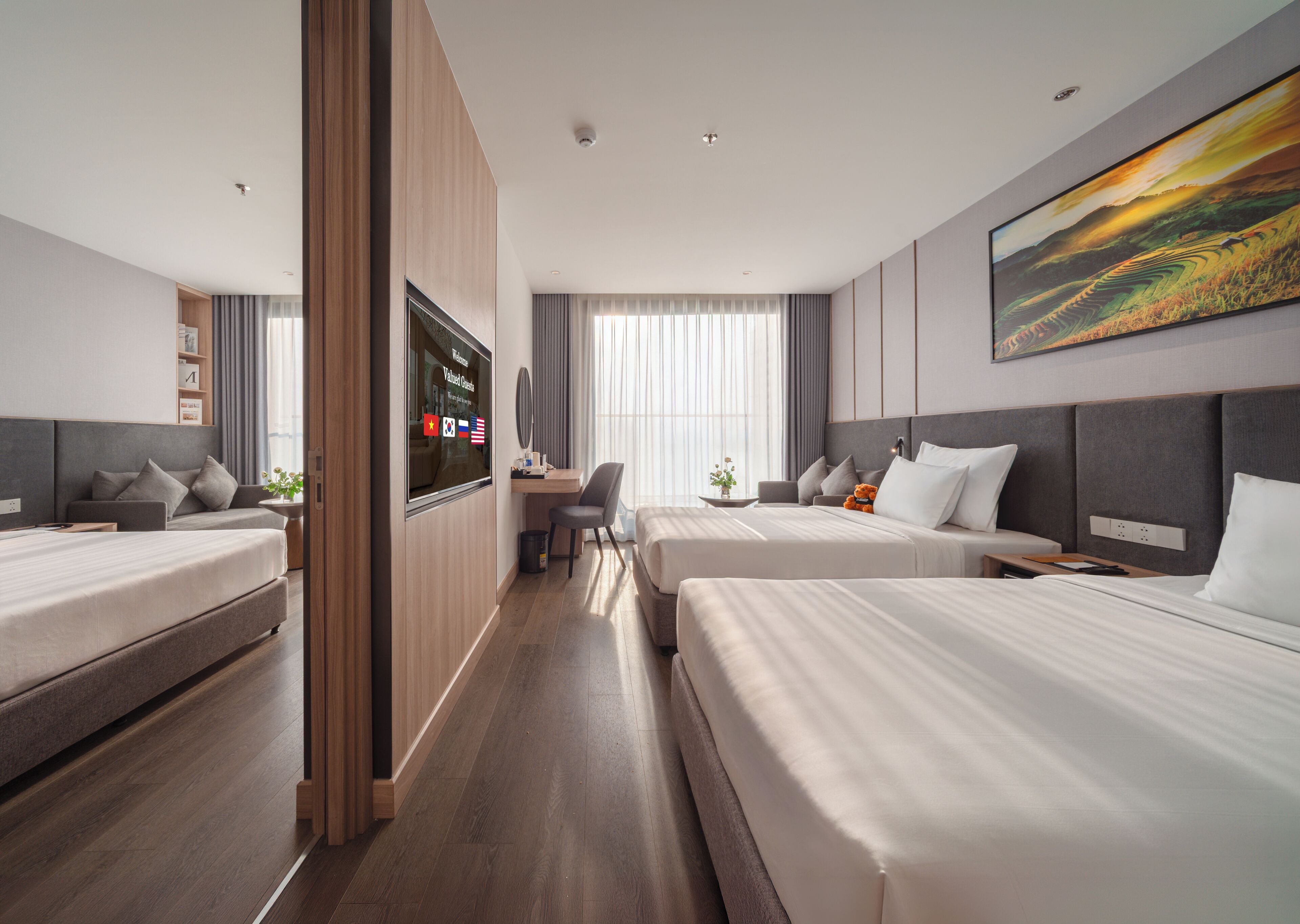 Une chambre d’hôtel avec deux lits, un bureau, une télévision et une grande fenêtre.