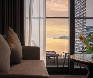 Una sala de estar moderna con un sofá, una mesita y vistas al mar a través de amplias ventanas.