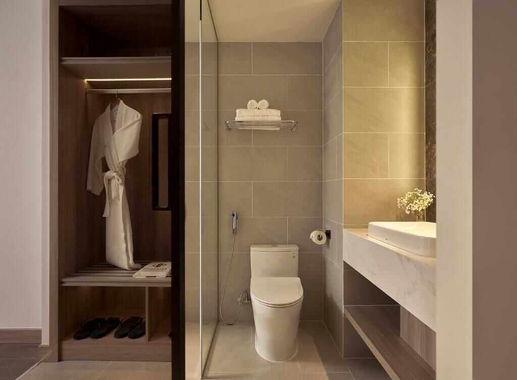 A modern bathroom with a toilet, shower, and a vanity with a mirror.