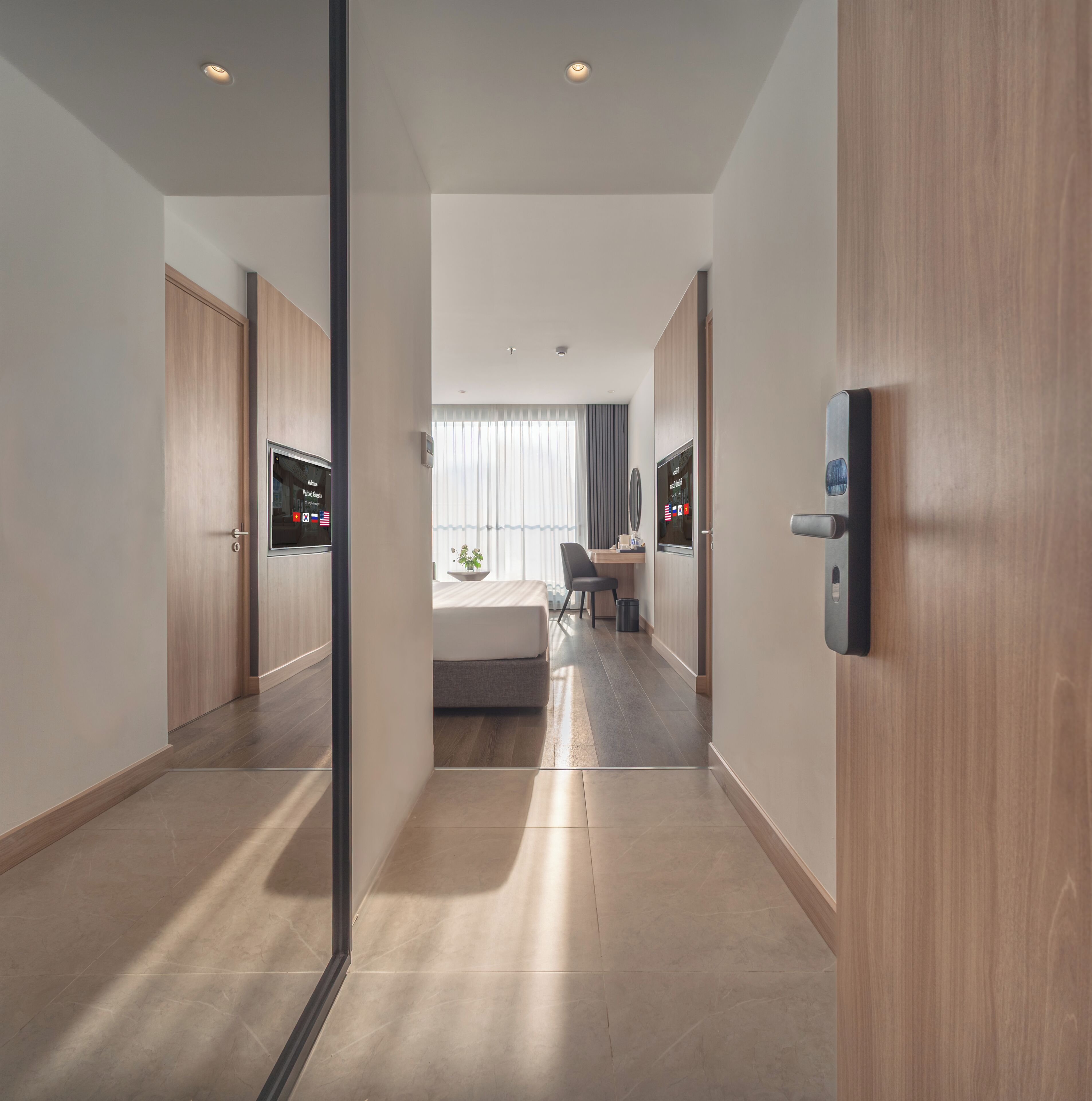 Habitació d'hotel moderna amb llit, escriptori, cadira i televisió.