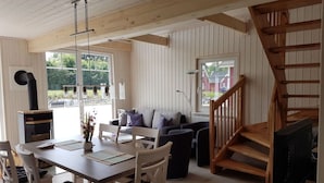 A cozy interior with a dining area, a sofa set, and a wooden staircase. - Beaver Modern Retreat (Wandlitz)