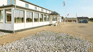 Un bâtiment moderne doté de grandes fenêtres et d’une entrée abritée.