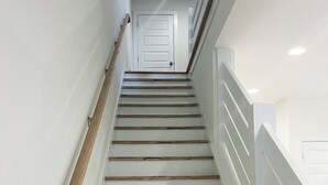 A staircase with wooden steps and white walls, leading to a door at the top. - Back To College! 3 Bed Rooms 2.5 Bathroom- College Street near 280 (Auburn)