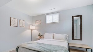 A bedroom with a bed, bedside lamp, and a small table. - Colorado Bay B (Colorado Springs)