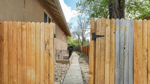A wooden gate with the number 2531, leading to a pathway with a concrete surface and a small rock garden. - Colorado Bay B (Colorado Springs)