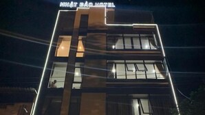 A multi-story building with a sign for Nhất Bảo Hotel and a spa. - Nhat Bao Hotel Ha Giang - by Bay Luxury (Ha Giang 1)