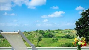 Un espace aménagé au bord de la piscine, offrant une vue sur un paysage verdoyant et des collines.