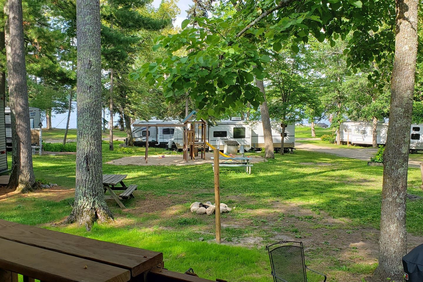 A campground with RVs, picnic tables, and a playground.