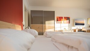 A hotel room with two beds, a wooden headboard, a sliding door closet, and a TV on the wall. - Small Studio in Neuastenberg With Balcony (Winterberg)