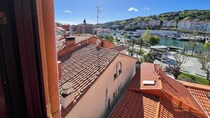 A view from a balcony overlooking a marina with boats, buildings, and a hilly landscape. - Bermeo Park - Centrica Casa Independiente (Bermeo)
