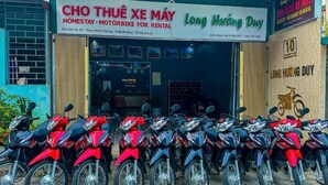 A motorcycle rental shop with a signboard and several motorcycles parked outside. - Long Huong Duy Hostel Ha Giang-BayLuxury (Ha Giang 2)
