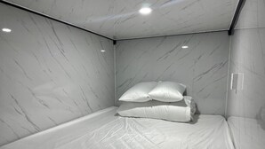 A small, modern room with a bed, marble walls, and recessed ceiling lights. - Long Huong Duy Hostel Ha Giang-BayLuxury (Ha Giang 2)