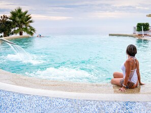 A person sitting by a pool with a clear view of the ocean and palm trees. - Flat in Caprioli di Pisciotta With sea View (Pisciotta)