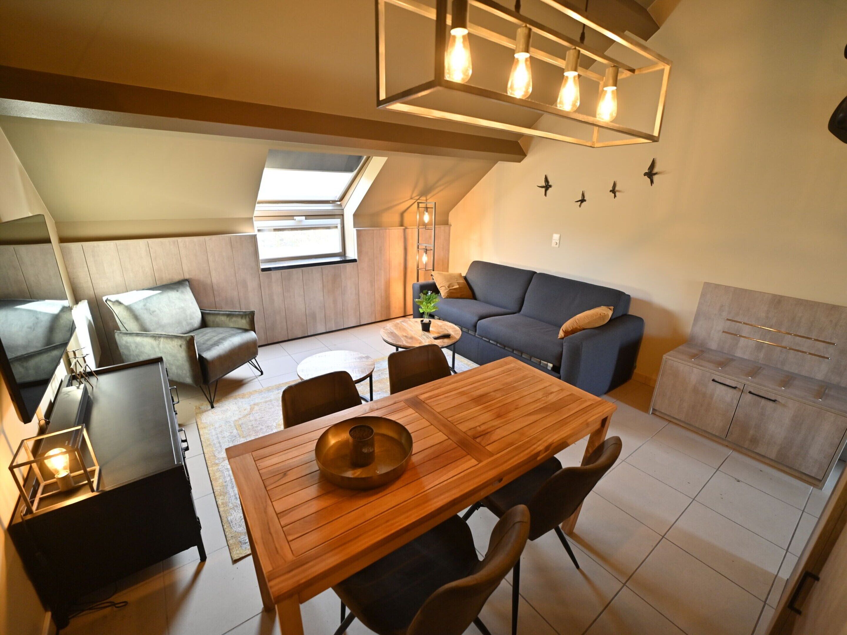 Een moderne woonkamer met een eethoek, een bank, een salontafel en een plafondlamp.