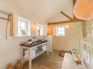 A bathroom with a wooden vanity, a towel rack, a sink, and a shower area. - Holiday Home in Oostduinkerke (Koksijde)