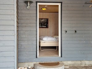 A narrow doorway leading to a room with a bed, a small rug, and a picture on the wall. - 4 Star Holiday Home in Glesborg (Glesborg)