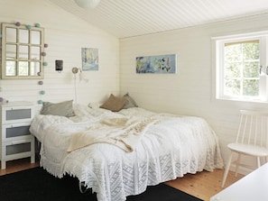A bedroom with a bed, a dresser, a chair, and two paintings on the wall. - 4 Star Holiday Home in Norrtalje (Norrtälje)