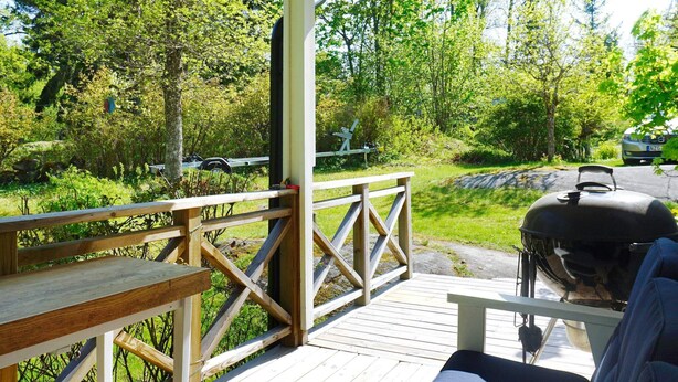 A covered outdoor seating area with a grill and a bench. - 4 Star Holiday Home in Norrtalje (Norrtälje)
