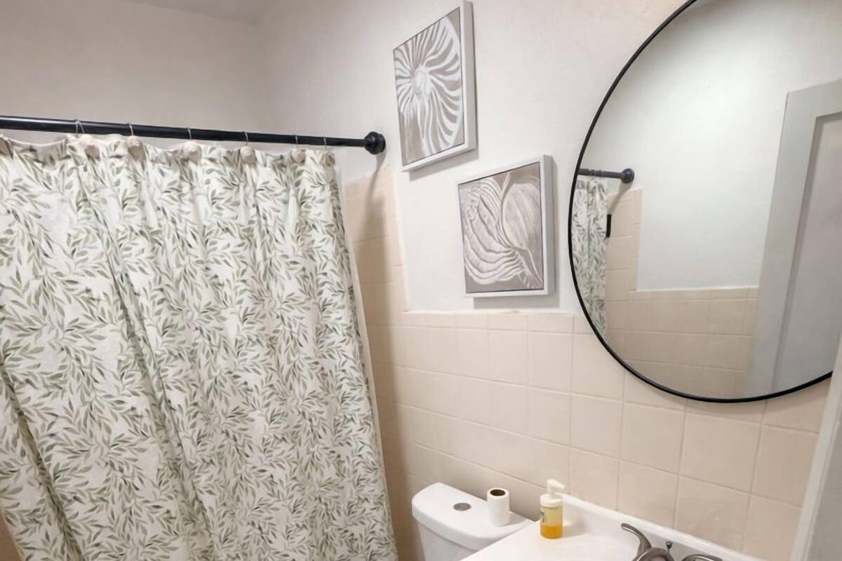 A bathroom with a toilet, sink, and shower curtain.