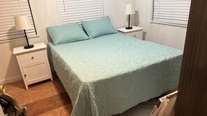 A bedroom with a bed, two bedside tables, a nightstand, and a lamp. - La Mare (Fort Lauderdale)