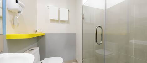 A modern bathroom with a toilet, sink, and glass shower enclosure.